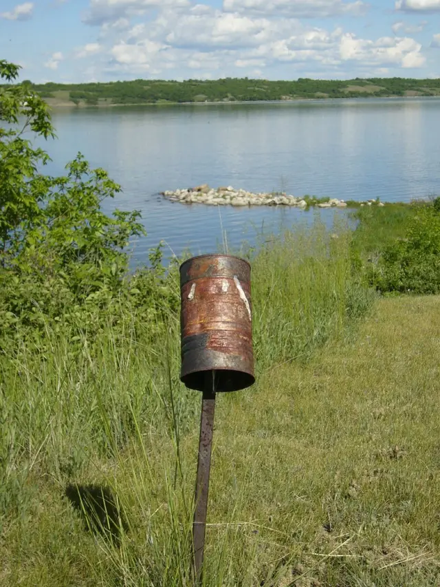 Rusty tin can on a post by the lake